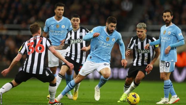 Manchester City's Josko Gvardiol attempts to shield the ball from three Newcastle players
